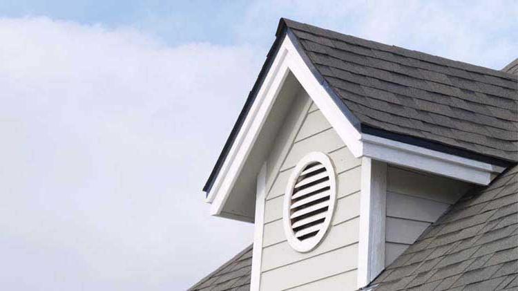 An attic gable with a circular vent.
